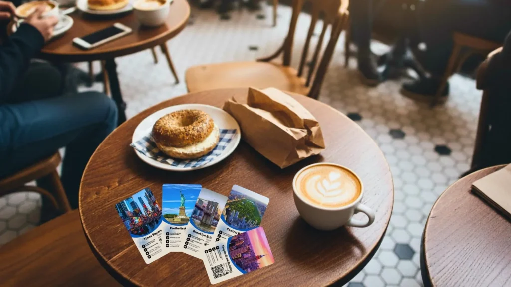 Aktuelle Entdeckerkarten auf Café-Tisch mit Kaffee und Bagel für Entdecker, die mehr fühlen wollen als KI-Listen